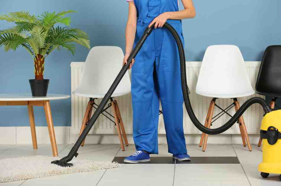 woman-uniform-vacuuming-floor-office-closeup (1)